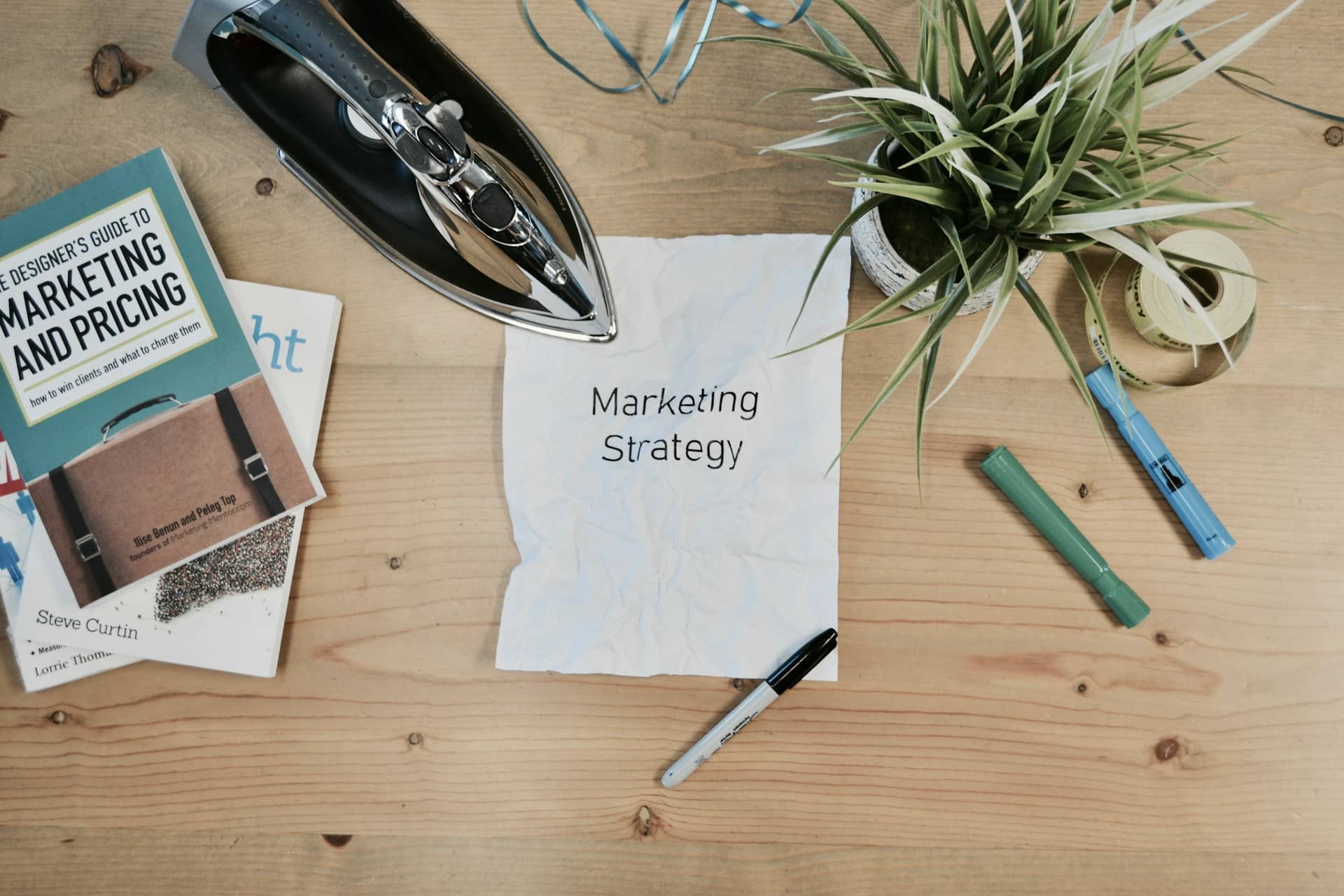 Op deze afbeelding is er een tafel te zien met daarop een papier waar marketing strategie in het engels opstaat, wat mooi past bij het thema marketing in je ondernemersplan.