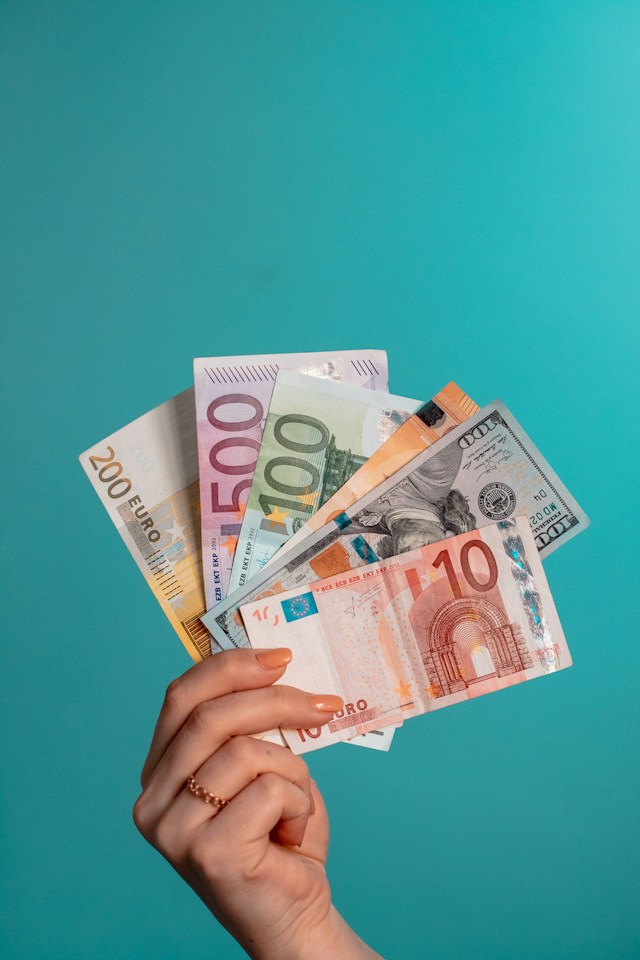 Op deze foto is er een hand die eurobiljetten vasthoudt. Het weerspiegelt het belang van het strategisch aspect binnen je ondernemersplan.